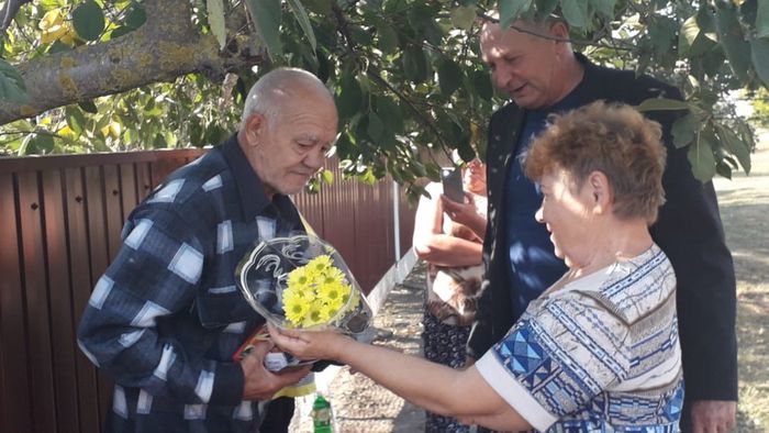 Глава поселения - Олейник А.Н. и председатель Совета ветеранов Т.А.Белоусова вручают цветы и памятные подарки виновнику торжества